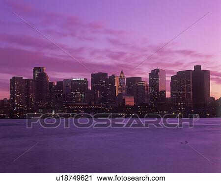Stock Image - Skyline and harbor view of Boston, Massachusetts at sunset. Fotosearch