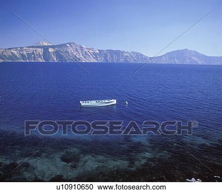 Stock Image - Solitary row boat in Crater Lake, in Oregon. Fotosearch