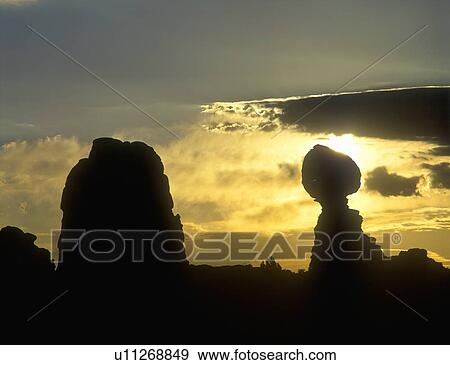 Stock Photo - Sunrise silhouette of sandstone rock formations in Arches National Park, UT . Fotosearch