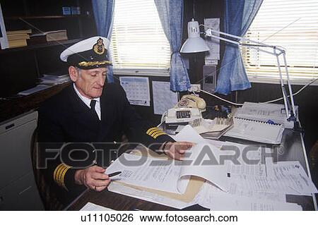 The captain of the ferry Bluenose doing paperwork at his desk View Large Photo Image Stock Photograph - The captain of the ferry Bluenose doing paperwork at his desk. Fotosearch