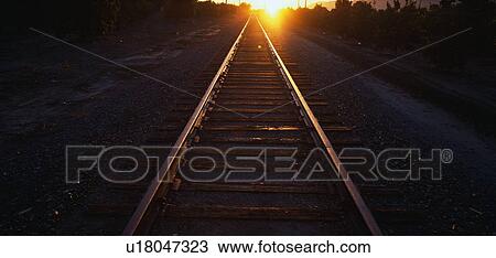 Stock Image - These are railroad tracks that go off into infinity at sunrise. Fotosearch