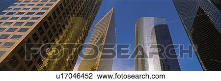 Stock Image - This is a view looking up at the office towers in Los Angeles. Light glistens on the side of the buildings.. Fotosearch