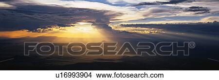 This is an image of the sun bursting through dark clouds View Large Photo Image Picture - This is an image of the sun bursting through dark clouds. Fotosearch