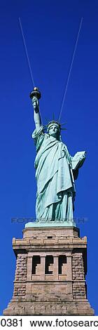 Stock Image - This is the Statue of Liberty on its full pedestal against a blue sky.. Fotosearch