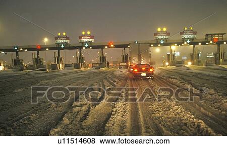 Stock Photo - Toll gate in New Jersey after winter snowstorm and much snow at night. Fotosearch