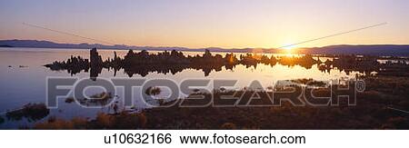 Stock Photograph - Tufa rock formations emerging from Mono Lake at sunrise, California. Fotosearch