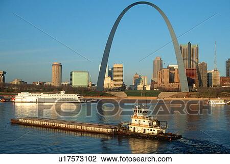 Stock Image - Tugboat pushing barge in front of Archway in St. Louis, Missouri. Fotosearch