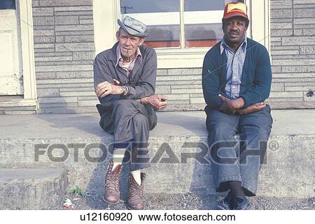 Two men down on their luck sitting on a bench View Large Photo Image Stock Image - Two men down on their luck sitting on a bench. Fotosearch