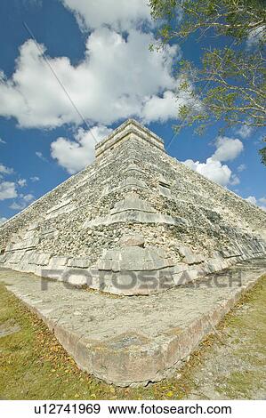 Stock Photo - White puffy clouds over the Mayan Pyramid of Kukulkan. Fotosearch