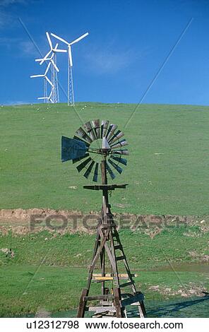 Stock Photo - Wooden windmill in foreground with wind turbines. Fotosearch