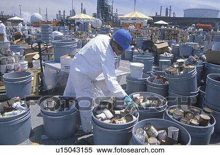 Stock Photography - Worker sorting toxic wastes at waste cleanup site on Earth Day. Fotosearch