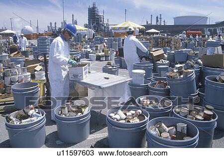 Stock Image - Workers handling toxic household wastes at waste cleanup site on Earth Day. Fotosearch