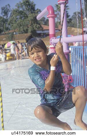 Stock Photo - A boy on a water fountain at waterpark. Fotosearch