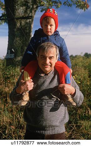 A boy sitting on his grandfather's shoulders View Large Photo Image Stock Photo - A boy sitting on his grandfather's shoulders. Fotosearch