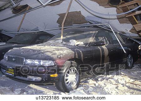 Stock Photography - A car at dealership crushed in the Los Angeles earthquake. Fotosearch
