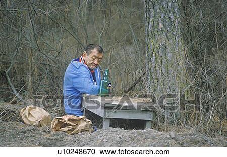A homeless man sitting on the ground with a bottle of alcohol View Large Photo Image Stock Image - A homeless man sitting on the ground with a bottle of alcohol. Fotosearch