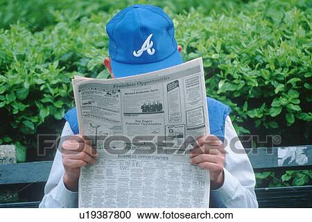 A man sitting on a bench reading the newspaper View Large Photo Image Stock Image - A man sitting on a bench reading the newspaper. Fotosearch
