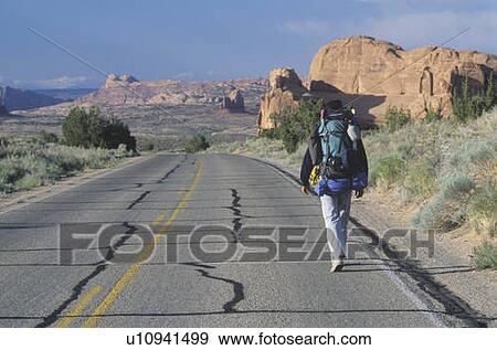 Stock Photo - A man walking on the highway. Fotosearch
