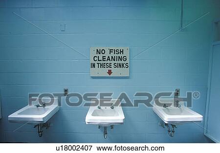 Stock Photo - A sign that reads “No fish cleaning in these sinks”. Fotosearch