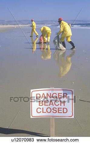 Stock Image - A sign warning Danger after an oil spill closed. Fotosearch
