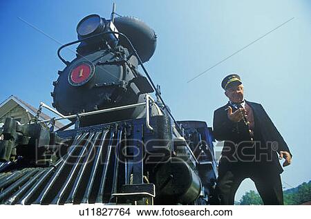 A steam engine conductor checks the time as he stands near the cowcatcher on the front, Eureka Springs, Arkansas View Large Photo Image Picture - A steam engine conductor checks the time as he stands near the cowcatcher on the front, Eureka Springs, Arkansas. Fotosearch