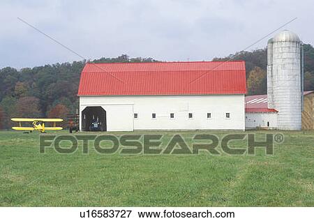 A yellow airplane, red barn, and grain silo on a farm View Large Photo Image Stock Photo - A yellow airplane, red barn, and grain silo on a farm. Fotosearch