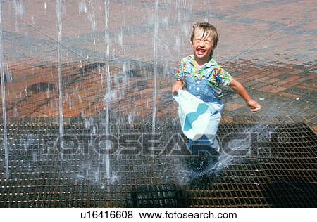 Boy playing in water fountain View Large Photo Image Stock Photo - Boy playing in water fountain. Fotosearch