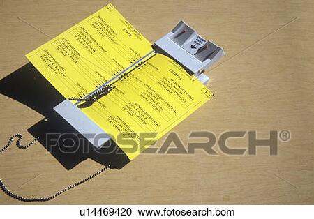 Stock Image - Close-up of a voting booth and ballot machine with ballot. Fotosearch