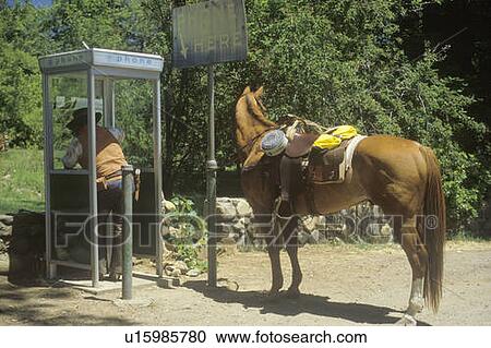 Stock Image - Cowboy making phone call. Fotosearch