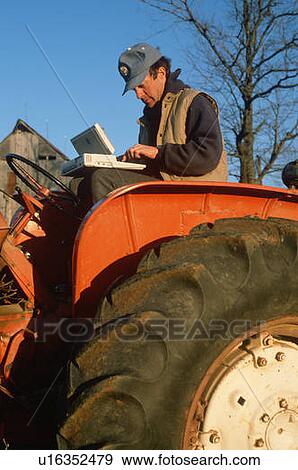 Farmer working on laptop computer on his tractor View Large Photo Image Stock Photo - Farmer working on laptop computer on his tractor. Fotosearch
