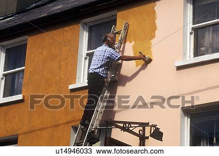 Stock Image - Man painting a house. Fotosearch