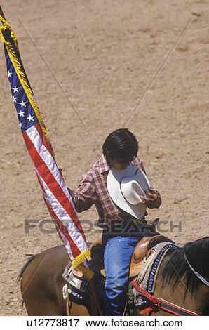 Stock Photo - Native American with American Flag at opening ceremony of Inter-Tribal Indian Rodeo, Gallup, NM. Fotosearch