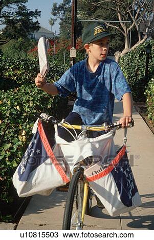 Stock Image - Newspaper delivery boy on bicycle. Fotosearch