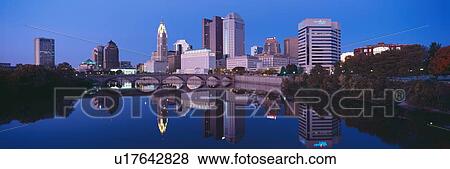 Stock Photo - Scioto River and Columbus Ohio skyline, the capital city, at dusk with lights on. Fotosearch