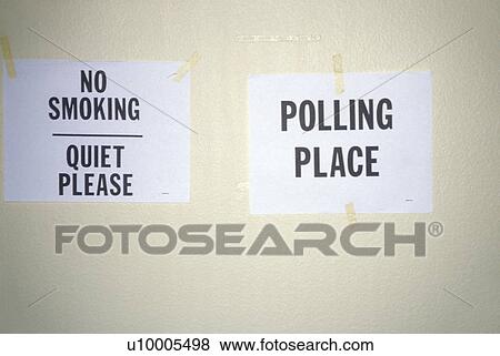 Stock Photo - Signs taped to the wall in a polling place read No Smoking and Polling Place. Fotosearch