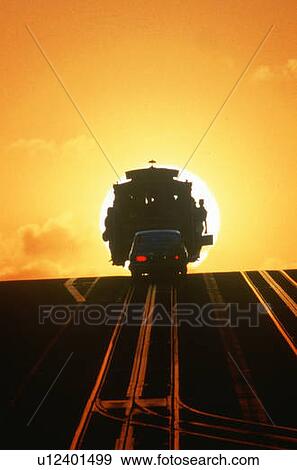 Stock Photo - Silhouetted cable car going over hill at sunset in San Francisco, California. Fotosearch
