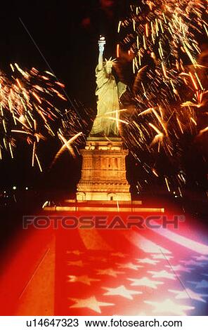 Stock Image - Statue of Liberty on 4th of July with fireworks and an American flag. Fotosearch