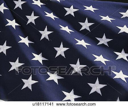 Stock Image - These are the stars of the American flag. They are against their blue field, climbing upward toward the corner of the image as if they were situated on small stairs that move up in levels.. . Fotosearch