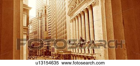 Stock Photography - This is a sepiatone view looking at the exterior of the New York Stock Exchange on Wall Street. It is framed by two white columns.. Fotosearch