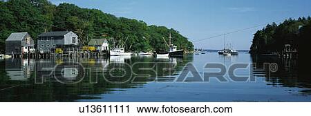 Stock Image - This is an open waterway where fishing boats are moored next to fishing shacks. Fotosearch