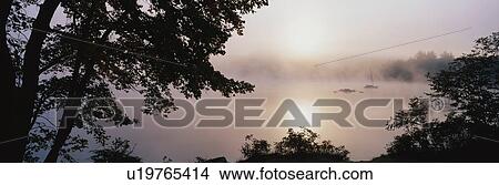 Picture - This is Squam Lake surrounded by a morning fog in autumn. Fotosearch