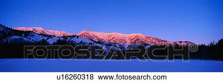 Stock Photo - This is the Snake Mountain Range with an alpen glow on the mountains.. Fotosearch
