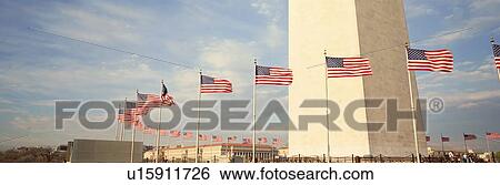Stock Photograph - United States Flags at the base of Washington Memorial. Fotosearch