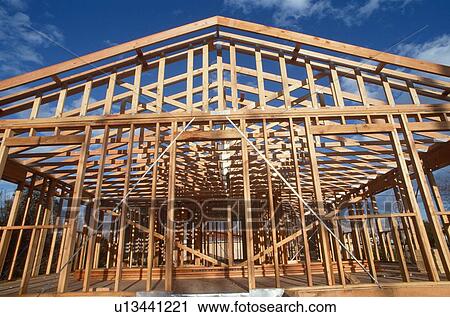 Stock Image - Wooden frame of house under construction. Fotosearch