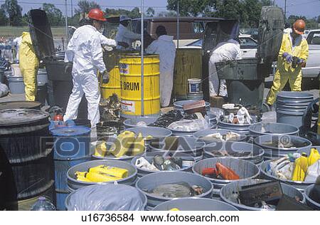 Picture - Workers handling toxic household wastes at waste cleanup site on Earth Day. Fotosearch