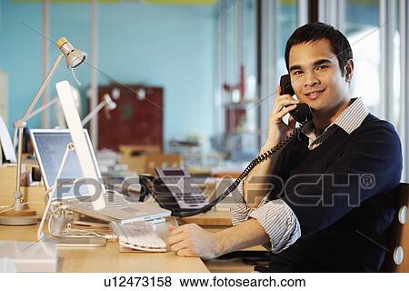 Businessman talking on the telephone in an office View Large Photo Image Stock Photo - Businessman talking on the telephone in an office. Fotosearch