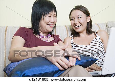 Close-up of a mature woman and her daughter using a laptop and smiling View Large Photo Image Stock Photography - Close-up of a mature woman and her daughter using a laptop and smiling. Fotosearch