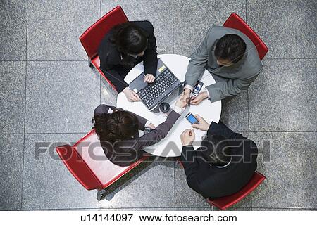 High angle view of two businesswomen with two businessmen in a conference room View Large Photo Image Stock Photo - High angle view of two businesswomen with two businessmen in a conference room. Fotosearch