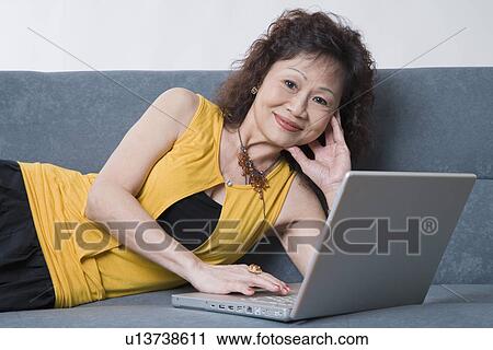 Portrait of a senior woman using a laptop and grinning View Large Photo Image Stock Image - Portrait of a senior woman using a laptop and grinning. Fotosearch
