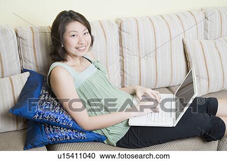 Portrait of a young woman using a laptop and smiling View Large Photo Image Stock Image - Portrait of a young woman using a laptop and smiling. Fotosearch